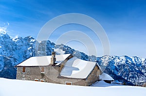 Mountain house partially submerged in snow