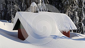 Mountain hut covered in snow photo