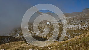 Mountain hut in the mist on Mangart saddle in Slovenia in Autumn