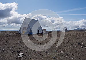 Mountain hut shelter Baldvinsskali at Fimmvorduhals pass on hiking trail. Red and black volcanic Iceland landscapea and