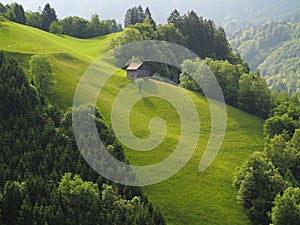 Mountain hut on steep green hill