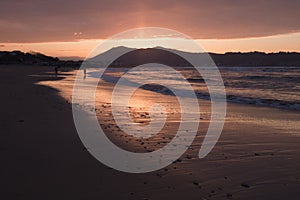 Mountain Jaizkibel backlit on atlantic coastline in beautiful pink sunset, hendaye, france