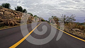 Mountain journey on asphalt road, car driving under blue sky. Road trip through mountains, scenic journey. Car travels