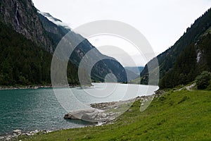 Mountain lake in the Alps on a cloudy summer day photo