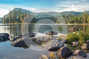 Mountain lake with big rocks on foreground