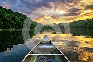 Mountain lake and canoe at sunset