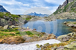 Mountain lake in hanging valley and melting snow