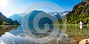 Mountain lake panorama with mountains and reflection in the lake