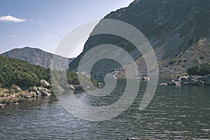 Mountain lake panorama view in late summer in Slovakian Carpathian Tatra with reflections of rocky hills in water. Rohacske plesa