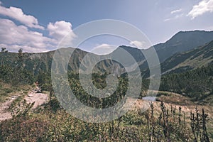 Mountain lake panorama view in late summer in Slovakian Carpathian Tatra with reflections of rocky hills in water. Rohacske plesa