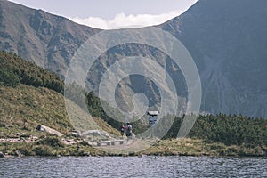 Mountain lake panorama view in late summer in Slovakian Carpathian Tatra with reflections of rocky hills in water. Rohacske plesa