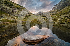 Mountain Lake with Rocks in Foreground at Sunset