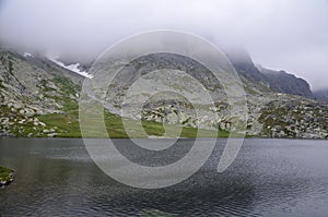 Mountain lake and rocks under cloudy sky in High Tatras National Park, Slovakia