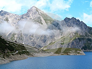Mountain lake with soft clouds high alpine landscape