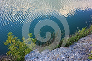 Mountain lake in the summer. Panoramic view on old flooded granite quarry with radon water.