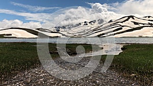 mountain lakes where snow water accumulates, magnificent zebra-patterned mountains and clouds that herald precipitation