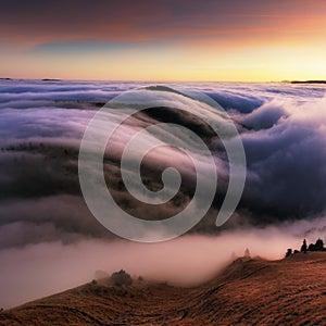 Mountain landscape above clouds at sunset in Slovakia with forest and sun