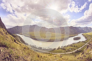 Mountain landscape. Blue sky. White clouds. Green trees. River