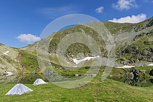 Mountain landscape with camping tents near the lake.