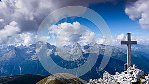 Mountain landscape with a cross on the summit and a great view behind