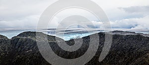 A mountain landscape with a Folgefonna glacier in the distance. A distant scenery of ice.