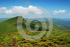 Mountain landscape with green hills and clouds