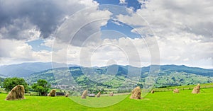 Mountain landscape with hayfield on the foreground