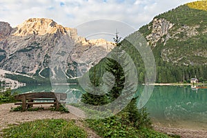 Mountain landscape of Lake Braies with a bench, a church and in the background the Croda del Becco