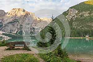 Mountain landscape of Lake Braies with a bench, a church and in the background the Croda del Becco photo