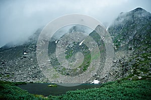 Mountain landscape. Lake, rocky mountains and clouds