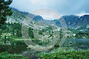 Mountain landscape. Lake, rocky mountains and clouds