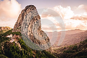 Mountain landscape with large rock formation. Roque de Agando. Hiking trail with sunset view of La Gomera, Canary Islands