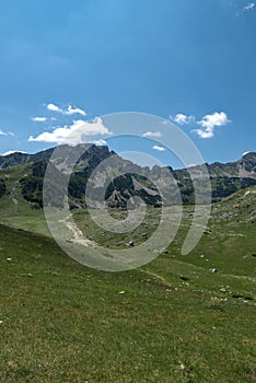 Mountain landscape. Mountains with green grass and bright blue sky. Idyllic panorama. Tourism concept. Hiking. Vacation