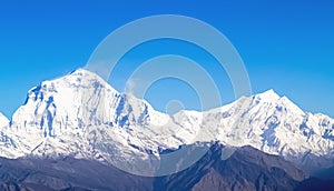 Mountain landscape panorama. Majestic mountain peaks covered with snow against a bright blue sky