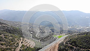 Mountain landscape with single empty car highway. Mountain passes from bird`s eye view