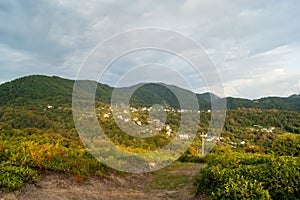 Mountain landscape - summer, mountains, sky and small houses in the lowlands