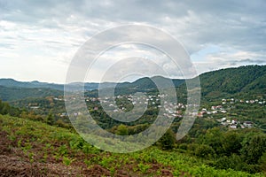 Mountain landscape - summer, mountains, sky and small houses in the lowlands