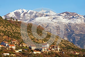 Mountain landscape on sunny winter day. Montenegro, view of snow-capped peaks of Lovcen mountain and Tivat town