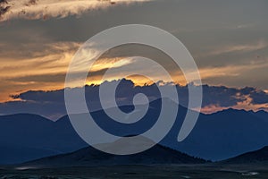 Mountain landscape at sunset. Outstanding view of the mountain ridges and clouds in Altai of Mongolia