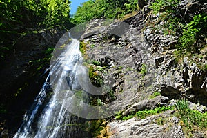 Horská krajina so Šútovským vodopádom, jedným z najvyšších vodopádov na Slovensku, počas letnej sezóny.
