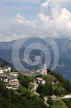Mountain landscape with the town of Guardia and its small church, Trentino, Italy photo