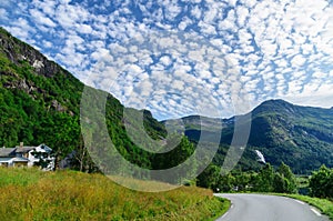 Mountain landscape with turning road and cirrostratus clouds