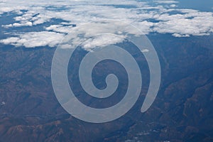 Mountain landscape viewed from aircraft window with white cloud