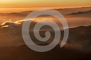 Mountain landscape with winter fog at sunse of Ceahlau, Romaniat