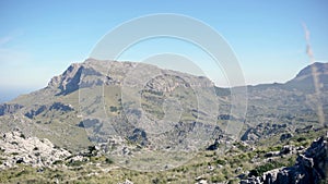 Mountain landscapes covered with green vegetation against blue sky. Art. Panorama of mountain valley with rocks covered