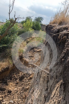 Mountain landslide disaster in sesmically dangerous area. Large cracks in earth, descent of large layers of earth blocking road. M