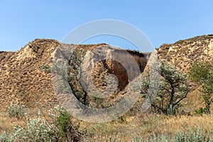 Mountain landslide in an environmentally hazardous area. Large cracks in earth, descent of large layers of earth blocking road.