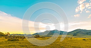 Mountain meadow time-lapse at the summer or autumn sunrise time. Wild nature and rural field. Clouds movement, green