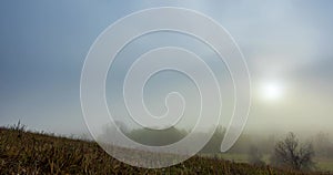 Mountain meadow timelapse at the autumn sunrise time. Wild nature and rural grass field. Morning heavy fog, sun rays and