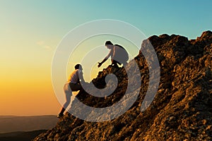 Man Rock Climbing with another Man Helping photo